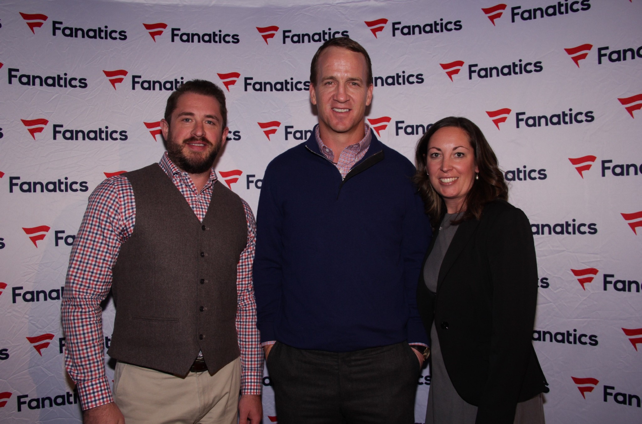 Peyton Manning posing with the owners of 5280 Custom Framing at an event